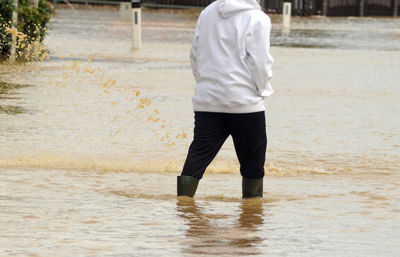 Rear view of man standing in water