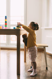 A little girl sorts colorful geometric shapes. development of motor skills. 