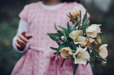 Midsection of girl holding bouquet