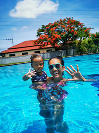 Portrait of mother and little daughter in swimming pool