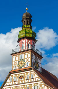 Low angle view of clock tower against cloudy sky