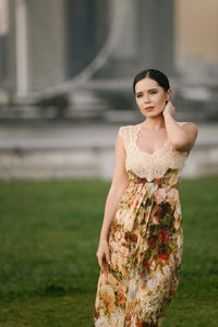 Portrait of young woman standing on field