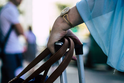 Close-up of hand holding railing against blurred background