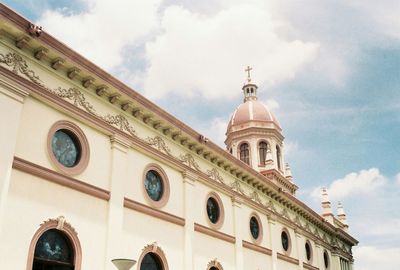 Low angle view of building against cloudy sky