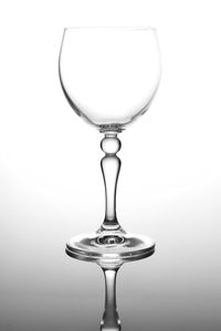 Close-up of wineglass on table against white background