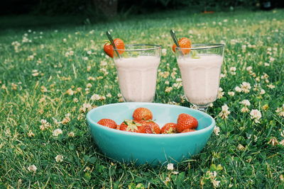 Close-up of strawberries in bowl with drinks