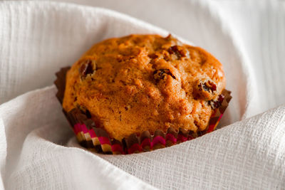 Homemade muffins with raisins on a wooden background. cupcake in a paper mold on a white napkin.