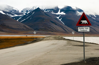 Road by mountains against sky