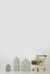 House model in mini shopping cart on the white background. buy a house. concept for property ladder