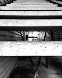 Empty bench by staircase against building