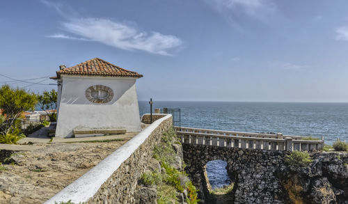 Building by sea against sky