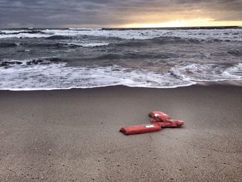 Torn life jacket at beach during sunset