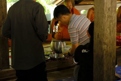 Rear view of friends standing by table