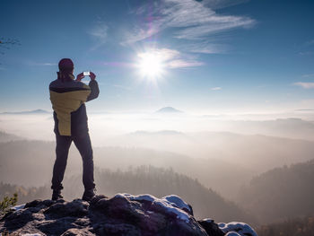 Man standing on mountain against sky