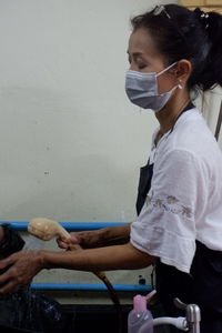 Side view of woman sitting on wall