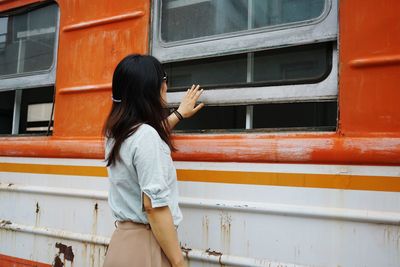 Side view of woman standing by train at station