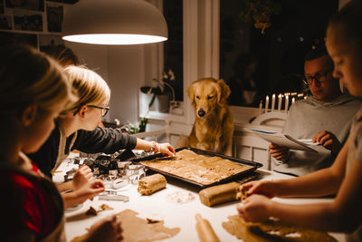 Family at table preparing gingerbread