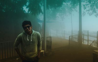 Young man standing in foggy weather