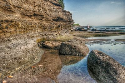 Rocks on beach against sky