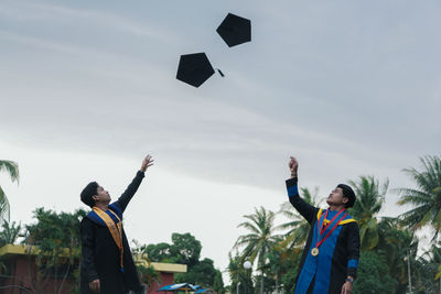 People with umbrella standing against sky