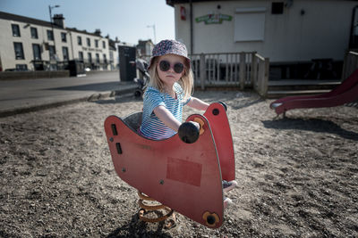 Portrait of girl wearing sunglasses playing at playground