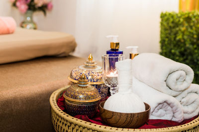 Close-up of towels with containers in wicker basket on table at home