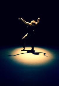 Full length of man standing on illuminated stage