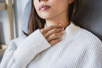 Midsection of woman wearing white sweater