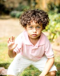 Portrait of cute boy gesturing while standing outdoors