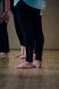 Low section of women standing on hardwood floor