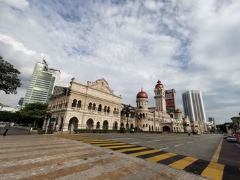 Buildings in city against cloudy sky