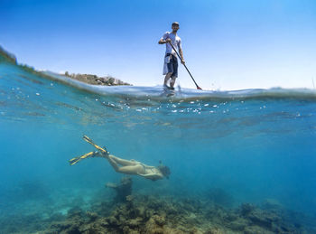 Young couple have a fun in ocean water, underwater view