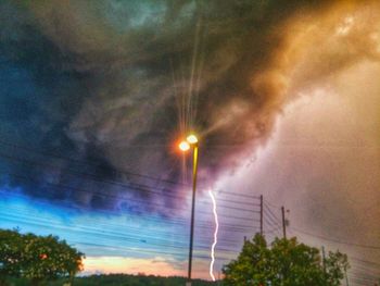 Low angle view of street light against cloudy sky