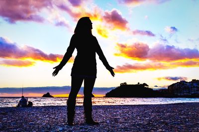 Silhouette people on beach at sunset