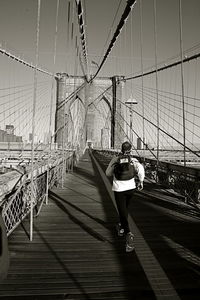 Rear view of woman standing on bridge
