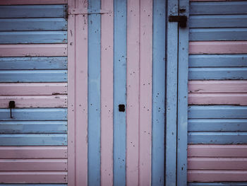 Full frame shot of pink and blue wooden beach hut close up details