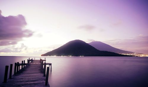 Pier over sea against sky during sunset