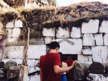 Rear view of man standing against wall