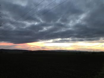 Scenic view of silhouette field against sky during sunset