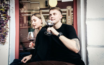 Young couple sitting on wall