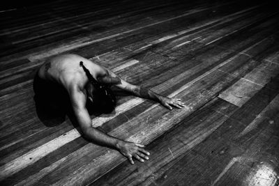 High angle view of man lying on hardwood floor