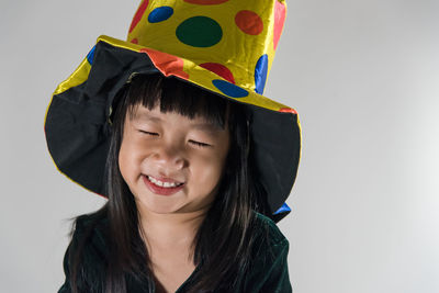 Close-up of smiling boy against white background