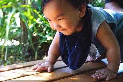 Close-up of baby boy crawling on wooden floor