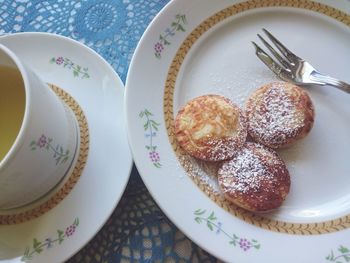 High angle view of poffertjes and tea on table