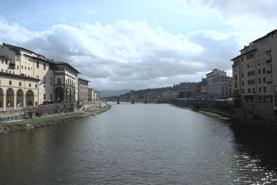 View of river amidst buildings against sky