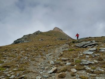 Low angle view of man standing on mountain against sky