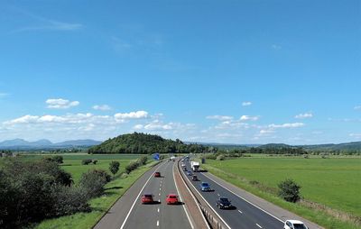 Vehicles on highway against sky