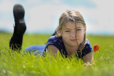Portrait of girl lying on grassy field