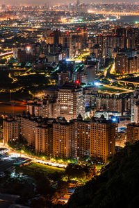 High angle view of illuminated buildings in city at night