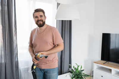 Side view of young man standing at home